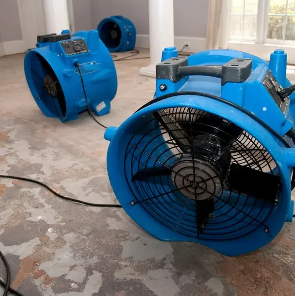 Air movers drying a wet floor during a water damage dry-out